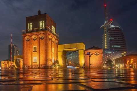 View of the old bascule bridge, the Klimahaus and a hotel in Bremerhaven at night, Bremerhaven,