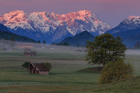 Hut and meadow in front of mountain range, morning light, spring, snowy, view of Zugspitze,