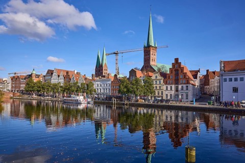 River Trave with quay wall, historical buildings, church towers of St. Marien and St. Petri,