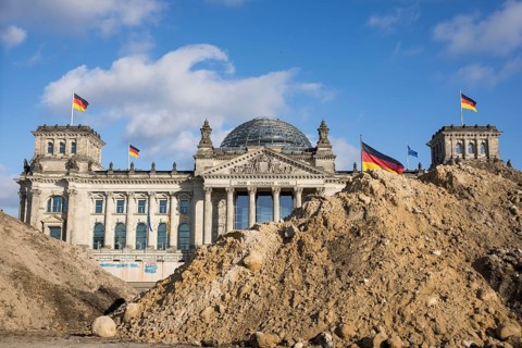 Reichstag building in Berlin Mitte behind Sandbergen due to construction work on the Platz der