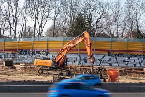 Excavator working on a construction site next to a graffiti-covered wall, Magdeburg, Saxony-Anhalt,