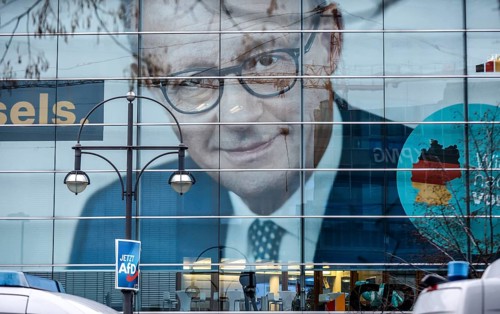 An AfD poster hangs in front of the portrait of CDU chancellor candidate Friedrich Merz at the CDU