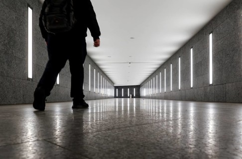 A man walks through the tunnel subway illuminated with LED light to the underground station Museum
