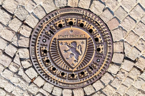 Manhole cover with the coat of arms of the town of Oschatz, Saxony, Germany, Europe