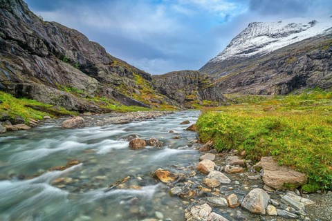 Mountain stream at Trollstigen, snow-covered mountain in the background, Alnestinden, Åndalsnes,