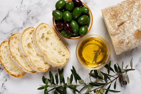 Appetizer, sliced ciabatta bread, with olive oil, green olives, Chalkidiki olives, classic Green