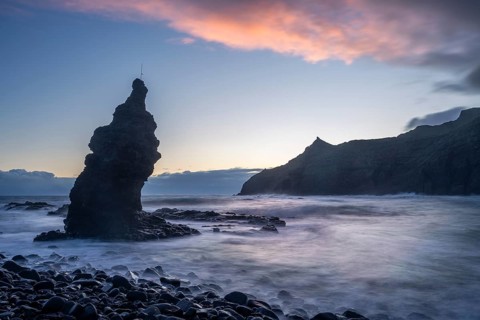 Sunrise on the beach at Playa de La Caleta with Punta San Lorenzo. Rocks and sea. Coloured clouds