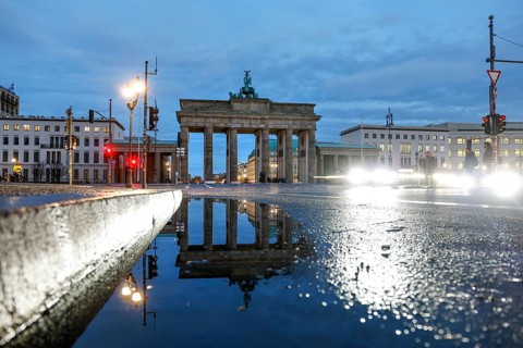 The Brandenburg Tor is reflected in a puddle, cars with lights switched on, Berlin, 27.01.2025,