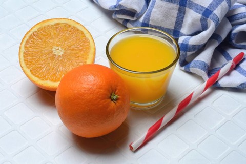 Orange juice in glass and orange, straw