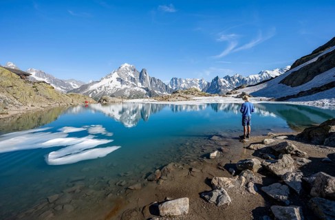 Mountaineer in front of mountain landscape with mountain lake, tourist at Lac Blanc with water