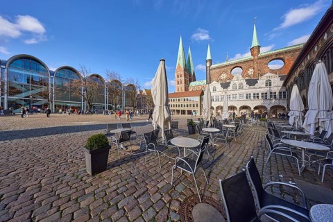 Church tower of St. Marien zu Lübeck, outdoor area of Café Niederegger - arcade café with tables,