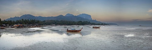 Before sunrise, longtail boats lie at low tide in the harbour at Sivalai Beach, Koh Mook Island,