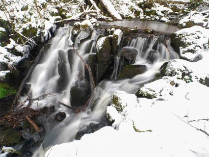 Teufelsmühle waterfall on the hill stream the Schwartzbach, in snow and ice in November. The Rhön