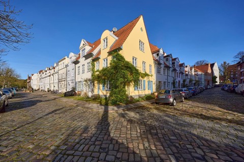 Historic houses, cobblestone pavement, blue cloudless sky, street crossing Elfengrube with An der