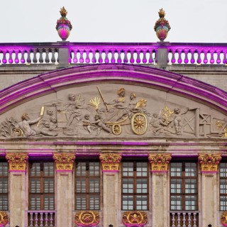 The illuminated gable of the guildhall Le Moulin à Vent and Pot d'Étain in the evening,