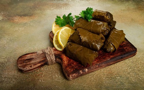 Dolma, minced meat with rice, in grape leaves, minced meat rolls, on a chopping board, top view, no