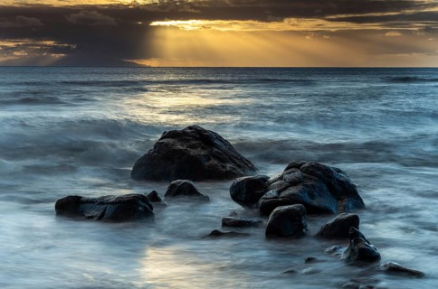 Rocks on the beach of Playa del Inglés. Sunset. Sea and waves. Long exposure. Valle Gran Rey, La