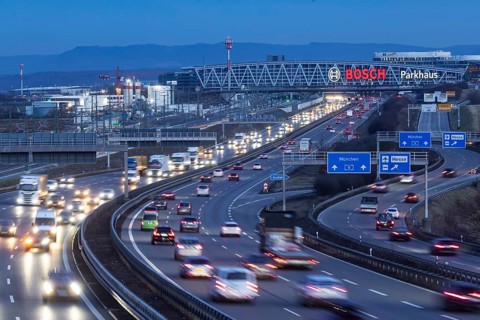 Heavy traffic in the evening on the A8 motorway at the airport. In the background, the Bosch bridge