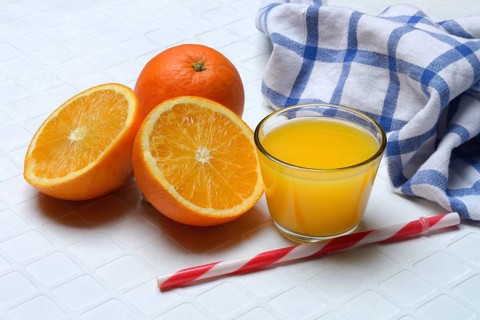 Orange juice in glass and orange, straw