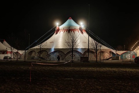Standard illuminated circus tent at night with bare trees, Böblingen, Germany, Europe