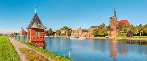 View over the Elbe harbour with water gauge tower to the old town with St. Stephen's Church, brick