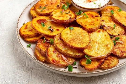 Crispy potato slices, with parmesan cheese and spices, fried in the oven, homemade, no people