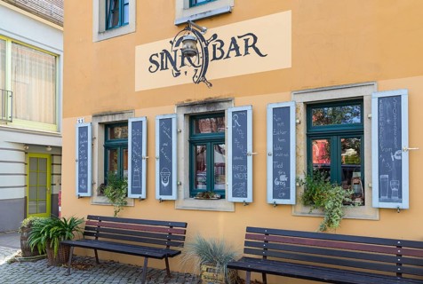 Exterior view of the Sinkbar pub with labelled shutters, village green of Altkötzschenbroda,