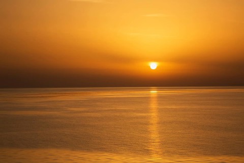 Setting golden sun over Adriatic sea taken from the top deck of a cruise ship in late summer, near