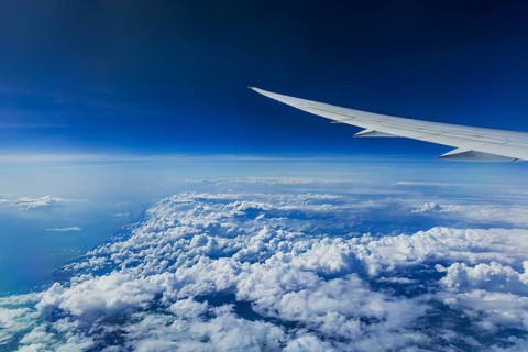 Above the clouds over the Indian Ocean. On the left, the coast of India. View from the aircraft