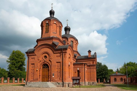 Red brick church with high towers and cloudy sky in the background, Orthodox Church of St Nicholas,