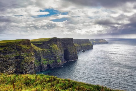 Cliffs of Moher in the haze, rain clouds on the horizon, Ireland, Europe