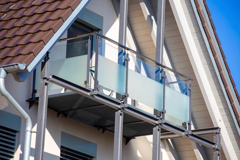 Balcony railing made of glass and stainless steel on a residential building