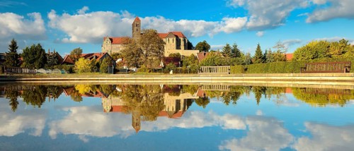 Castle hill with collegiate church of St. Servatius with reflection in water basin in autumn,