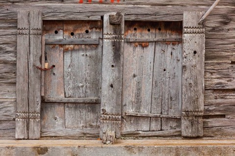Closed wooden window shutter. Historic village of Mühlebach, Valais, Switzerland, Europe