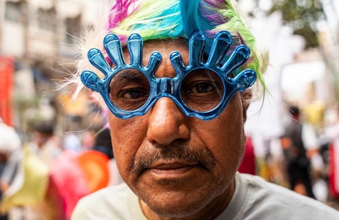 A person wears a holi sunglass in a market on the eve of Holi Festival, on March 13, 2025 in