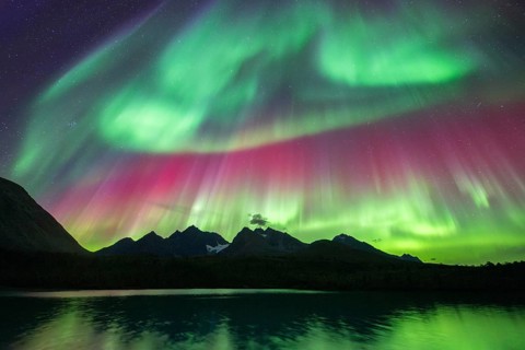 Northern lights over Bergen in the Lyngen Alps, reflection on the lake, Troms og Finnmark, Norway,