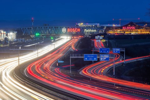 A8 motorway at Stuttgart Airport in the evening. Heavy traffic, lanes of light. Modern architecture