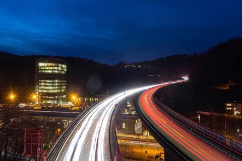 Federal road B14 at night, road bridge with traffic and light lanes. On the left the building of