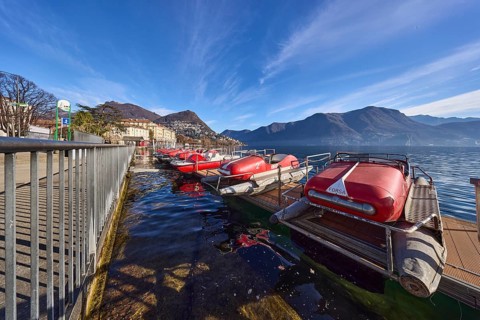 Pedal boats, metal railing, lake, shore, pavement, pedal boat rental, mountain landscape, haze,