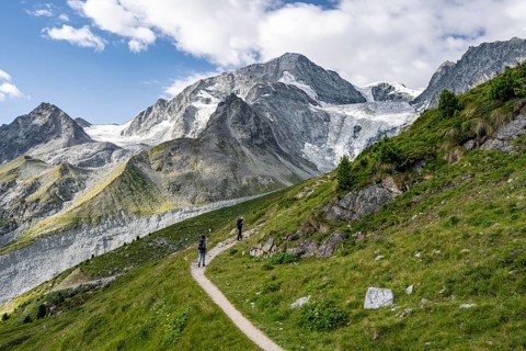 Mountaineer on a hiking trail, mountain landscape near Arolla, behind mountain peak Mont Collon and
