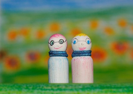 Two small funny wooden cones in front of a painted background, North Rhine-Westphalia, Germany,
