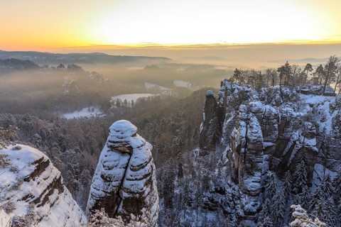 View from the Ferdinandstein into the Wehlgrund and to the rock castle Neurathen near snow, Bastei,