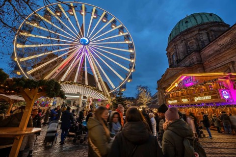Ferris wheel at the winter village, Christmas market at dusk, St Elisabeth's Church on the right,