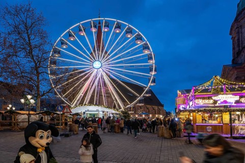 Ferris wheel at the winter village, Christmas market at dusk, St Elisabeth's Church on the right,