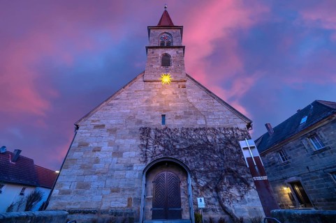 St Bartholomew's Church with poinsettia at dusk, Eschenau, Middle Franconia, Bavaria, Germany,