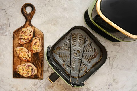 Juicy, golden-brown pork chops are arranged beautifully on a rustic wooden board, showcasing the