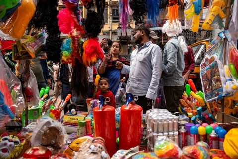People buy Holi celebration items in a market on the eve of Holi Festival, on March 13, 2025 in