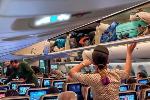 Etihad airline aircraft, interior, rows of seats with passengers. Boeing 787 aircraft on a flight