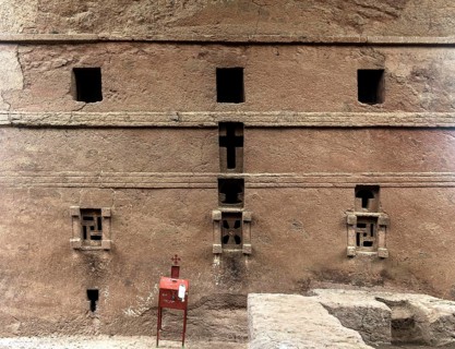 Underground monolithic rock church Biete Maryam, east side with cross windows carved in stone,