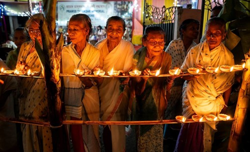 Elderly women of Pramod Talukdar Memorial Old Age Home light Diya oil lamps as they celebrate